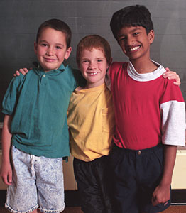 Three young students standing together smiling