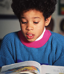 Young minority student reading from a book out loud